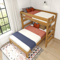 Twin-over-twin wooden bunk bed in natural oak with rust-orange throw pillows, blue bed runner and patterned rug in a bright modern farmhouse bedroom.