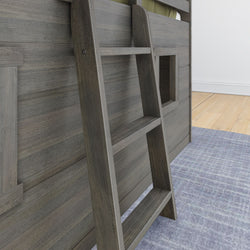 Wooden bunk bed ladder with a modern design on a blue patterned rug in a bright room.