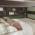 Cozy rustic bedroom with a bunk bed featuring built-in dark wood storage shelves and green beadboard wall, neutral beige bedding and plaid pillows, vintage radio and instant camera on the headboard shelves, headphones, portable fan, and handheld gaming console