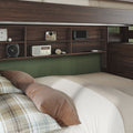 Cozy bedroom with dark wood built-in shelving headboard, green accent wall, beige bedding, plaid and brown pillows, retro radio, instant camera, handheld gaming console and headphones