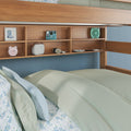 Bunk bed with built-in wooden shelving displaying retro alarm clock, instant camera, portable speaker and mint fan above floral pastel bedding and blue paneled wall