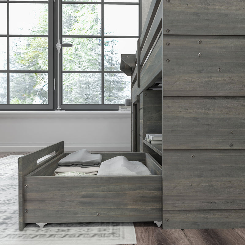 Under-bed storage drawer with folded clothes in a modern wooden bunk bed setup near a large window.