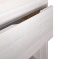 Close-up of a whitewashed wood drawer with integrated finger-pull handle and light wood grain finish for a modern nightstand