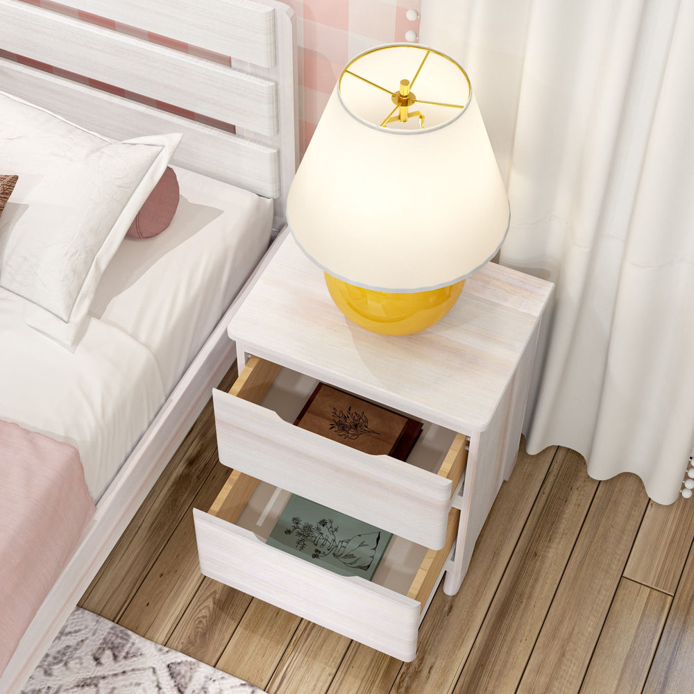 Modern white wooden nightstand with open drawers beside bed, featuring a decorative lamp on top.