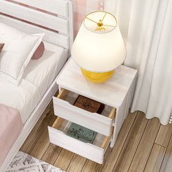 Modern white wooden nightstand with open drawers beside bed, featuring a decorative lamp on top.