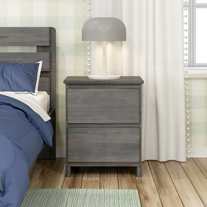 Gray wooden nightstand with lamp and bed in cozy bedroom setting.