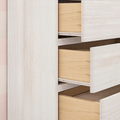 Scandinavian whitewashed dresser with open light-wood drawers showing minimalist bedroom storage and natural wood grain