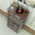 Vinyl record player turntable on a walnut top of a gray wooden dresser with open drawers filled with folded linens, mint green gingham wallpaper, hardwood floor and textured area rug, modern farmhouse bedroom decor