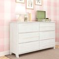 Whitewashed six-drawer dresser in pink gingham nursery with table lamp, children's books, green record player and framed botanical prints