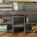Gray wooden loft bunk bed with built-in storage shelves and ladder, green bedding, wooden toy airplane and stacked boxes in kids bedroom