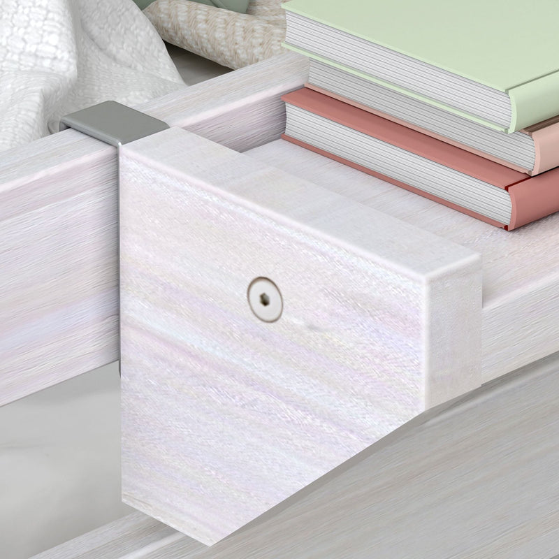 Close-up of whitewashed wooden bed frame corner with metal bracket and stacked pastel hardcover books, modern bedroom decor