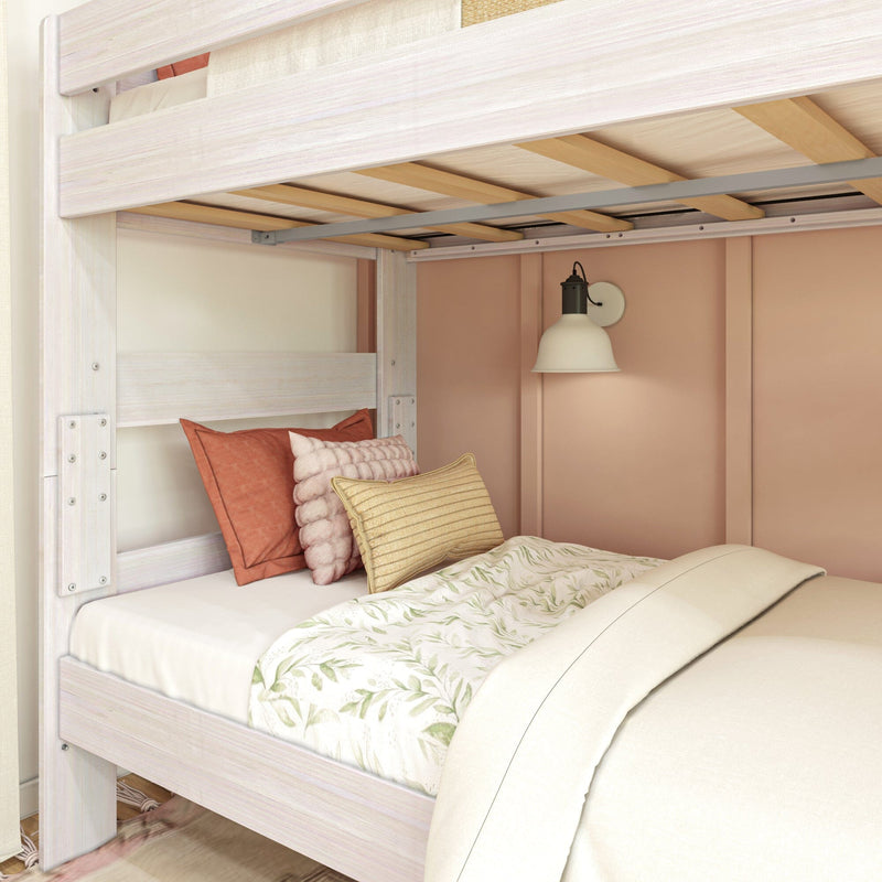 Cozy bunk bed with decorative pillows and soft lighting in a pastel-colored bedroom.
