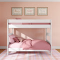White loft bunk bed with soft pink bedding and pillows in a pastel children's bedroom with peach wall, plaid rug and three framed horse prints