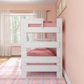White wooden bunk bed with pink bedding in pastel girls' bedroom, sheer curtains, large window, framed wall art and colorful plaid rug