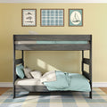 Wooden loft bunk bed with teal bedding, plaid rug and nautical framed art on yellow wall in kids' coastal bedroom