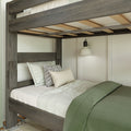 Gray reclaimed wood loft bunk bed with slatted plywood support, twin mattress, green duvet and striped accent pillows under a white wall sconce in a modern farmhouse bedroom