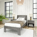 Modern farmhouse bedroom with gray wood bed and nightstands, neutral bedding and lamps, woven pendant light, chevron-pattern wallpaper, large black-framed windows and potted fern