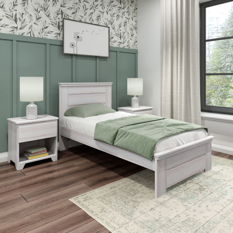 Modern farmhouse bedroom with green board-and-batten accent wall, whitewashed single bed and nightstands, green bedding, floral wallpaper, table lamps, and hardwood floor.