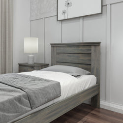 Rustic wooden bed frame in a modern bedroom with gray and white bedding, nightstand, and lamp.