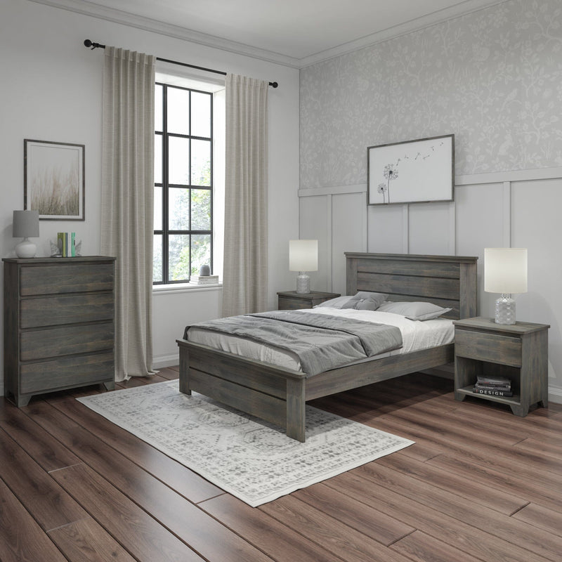 Modern farmhouse bedroom with gray wooden bed and matching nightstands, neutral linen curtains, patterned wallpaper, table lamps, and dark hardwood floors