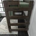 Dark walnut wood ladder attached to a twin loft bed with green bedding in a modern bedroom interior, patterned area rug and large window