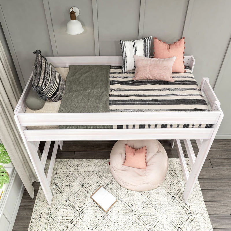 White twin loft bed with black-and-white striped bedding and pink accent pillows above cozy reading nook with round floor cushion and patterned rug
