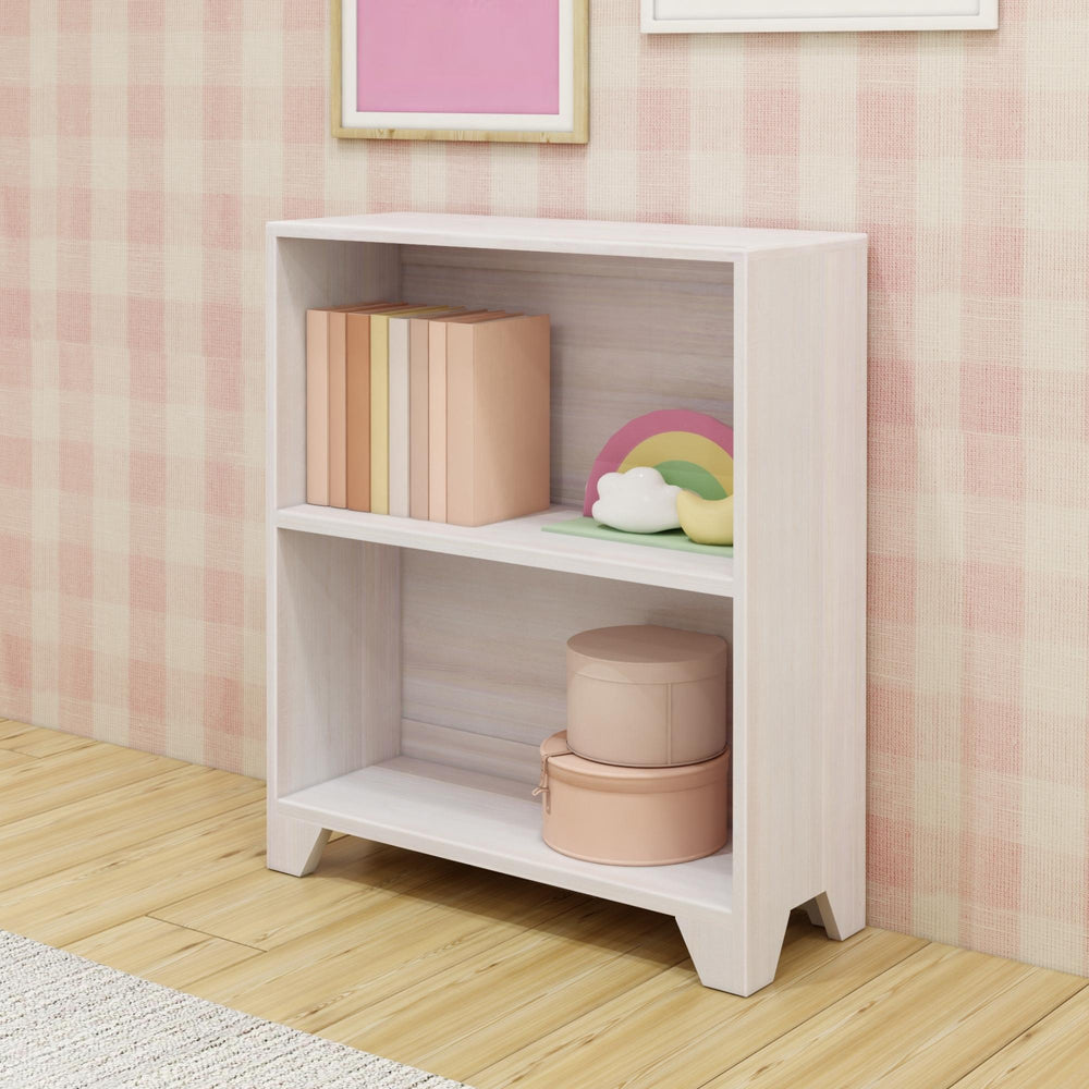White wooden bookshelf in a cozy room with books and decorative items on a light wood floor.