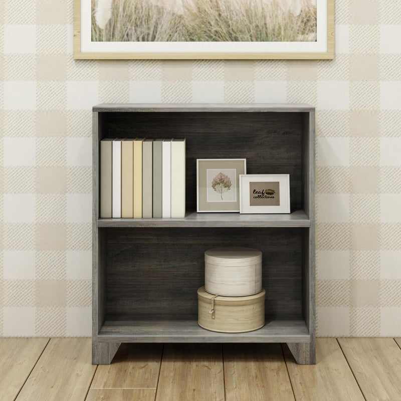Gray wooden bookshelf with books and decorative items in a cozy living room.