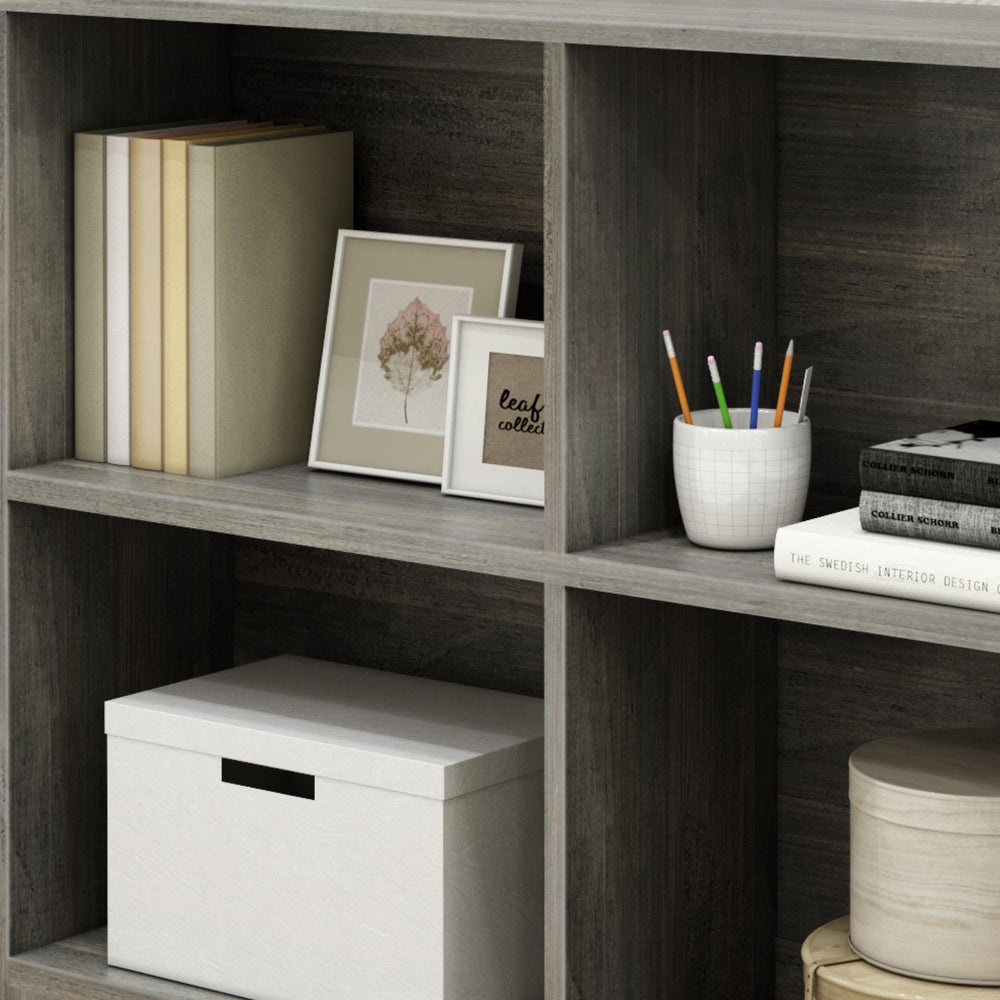 Wooden bookshelf with books, framed photos, pencils, and storage boxes for home decor and organization.