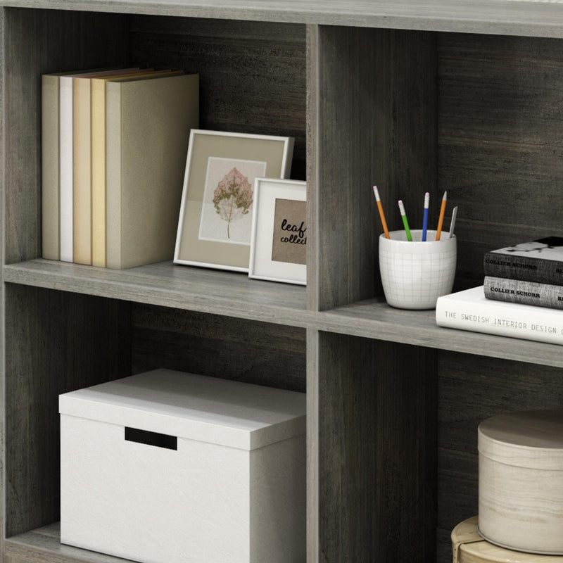 Wooden bookshelf with books, framed photos, pencils, and storage boxes for home decor and organization.