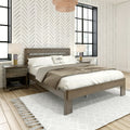 Modern bedroom with wooden platform bed, neutral taupe bedding, herringbone patterned wallpaper, black-framed windows, bedside lamps and woven pendant light