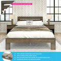 Solid pine platform bed with textured wood finish, slatted headboard, matching nightstands and lamps in a modern farmhouse bedroom with neutral bedding and herringbone wallpaper