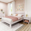 Cozy pink bedroom with whitewashed wooden bed, blush duvet and pillows, floral gallery wall, sheer pom-pom curtains, gold bedside lamps and feminine decor