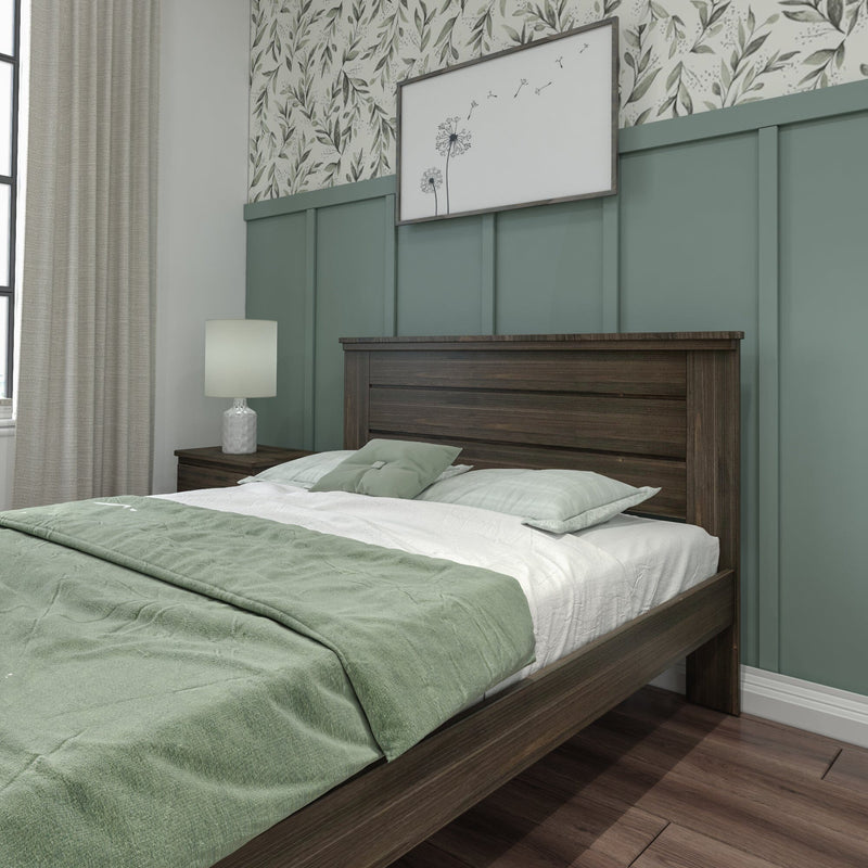 Modern bedroom with green bedding, wooden bed frame, and botanical wallpaper.