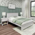 Modern farmhouse bedroom with green board-and-batten accent wall, whitewashed wood bed, sage green bedding, matching nightstands and lamps, floral wallpaper, sheer curtains and hardwood floors