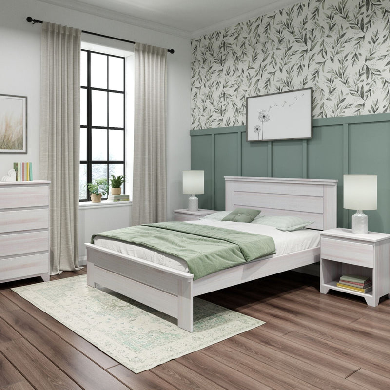 Modern farmhouse bedroom with light wood bed and nightstands, sage green paneled accent wall topped with botanical wallpaper, soft green bedding, beige curtains framing a black grid window, bedside lamps, potted plant, and dark hardwood floors