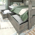 Gray wood platform bed frame with pull-out under-bed storage drawers, green duvet and patterned pillows in cozy bedroom