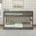 Gray wooden twin-over-twin bunk bed in neutral children's bedroom with plaid wallpaper, green pillows and framed grass artwork