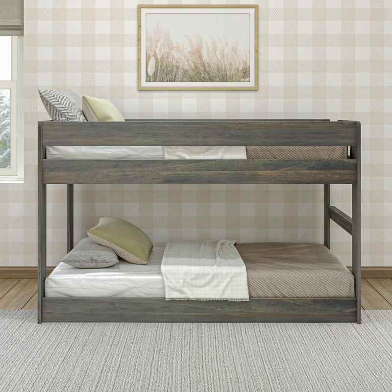 Gray wooden twin-over-twin bunk bed in neutral children's bedroom with plaid wallpaper, green pillows and framed grass artwork