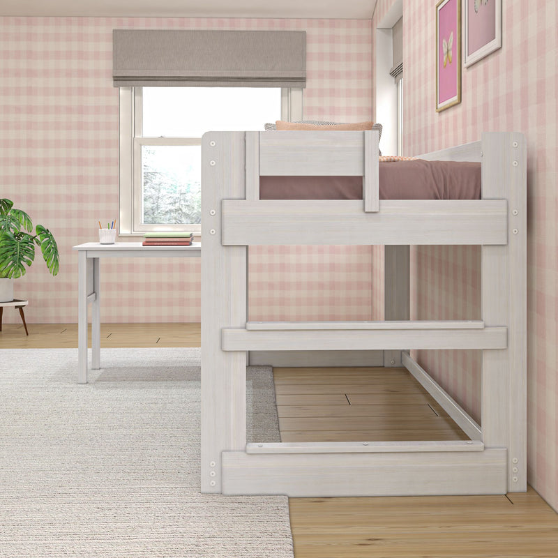 White wooden loft bunk bed and study desk in a child's bedroom with pink gingham wallpaper, window shade and houseplant