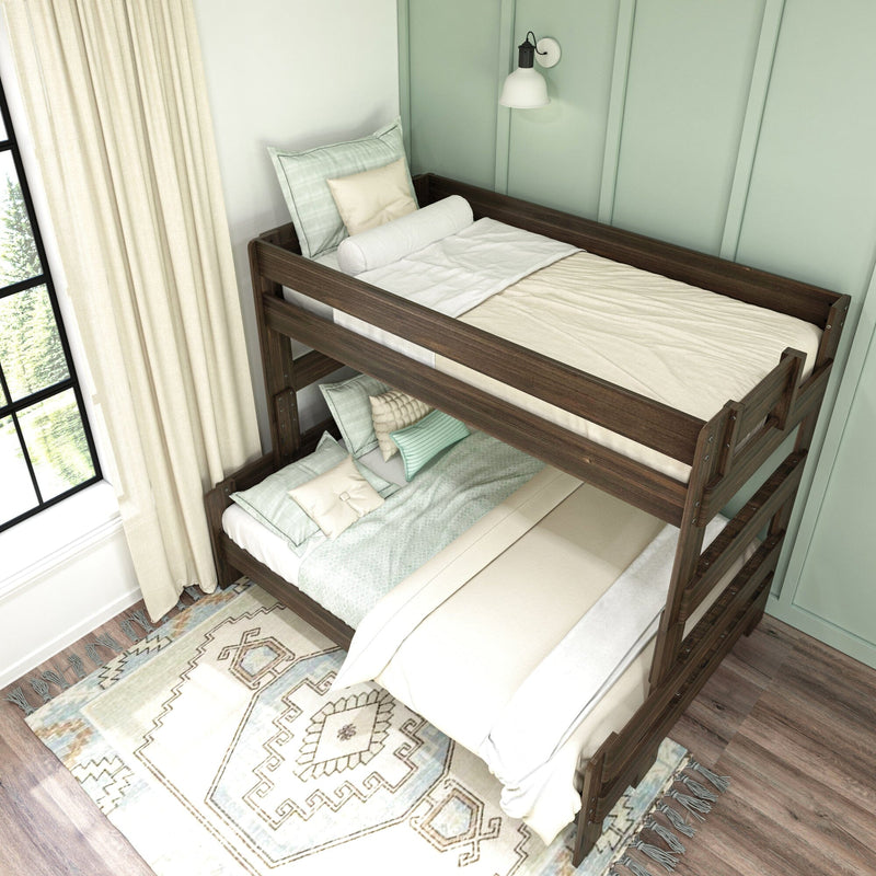 Dark wood twin bunk bed in cozy kids' bedroom with mint green accent wall, beige and mint bedding, wall-mounted reading lamp, patterned area rug and large window with natural light