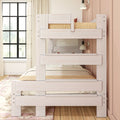 Whitewashed wooden twin-over-twin bunk bed with integrated guardrails and cozy bedding in a bright modern pink kids' bedroom with large window and hardwood floor
