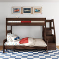 Wooden kids bunk bed in children's bedroom with car-themed bedding and pillows, red quilt, framed vintage car prints above and blue checkered rug