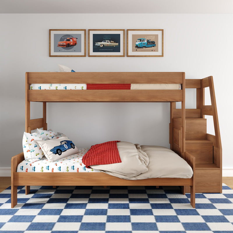 Solid wood bunk bed with side storage stairs in kids' bedroom, car-themed bedding and pillows, blue checkered rug, framed vintage car prints