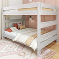 Whitewashed wooden bunk bed in a kids' bedroom with floral bedding, terracotta and mustard pillows, pink accent wall and patterned rug