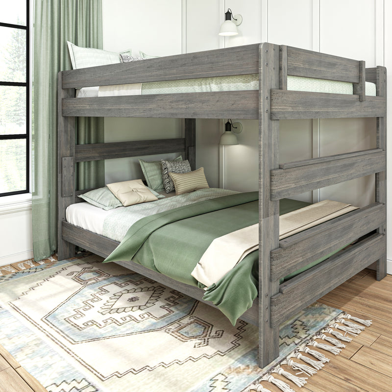 Gray reclaimed wood twin-over-full bunk bed with green bedding, patterned pillows and wall lamps in a farmhouse-style bedroom