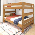 Solid wood twin-over-twin bunk bed in natural oak finish with guardrails, cozy pillows and throws on patterned rug in a modern kids' bedroom