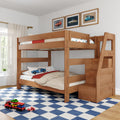 Natural wood twin-over-full bunk bed with built-in storage stairs in a children's bedroom, car-themed bedding and wall art, blue checkered rug and toy cars.