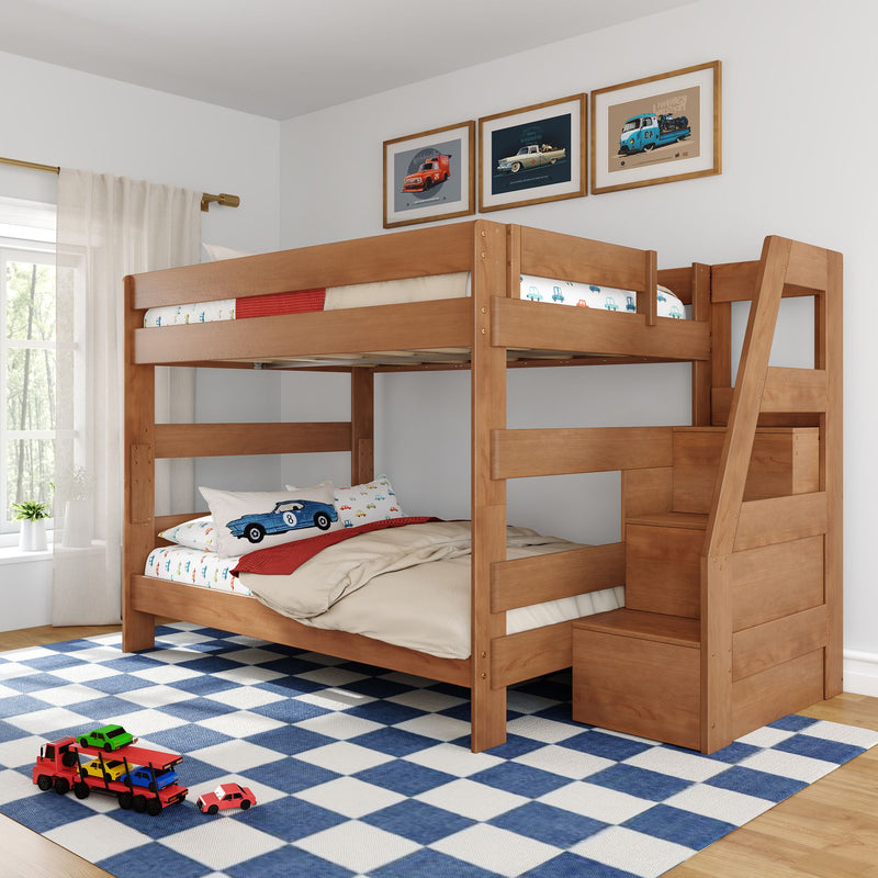 Natural wood twin-over-full bunk bed with built-in storage stairs in a children's bedroom, car-themed bedding and wall art, blue checkered rug and toy cars.
