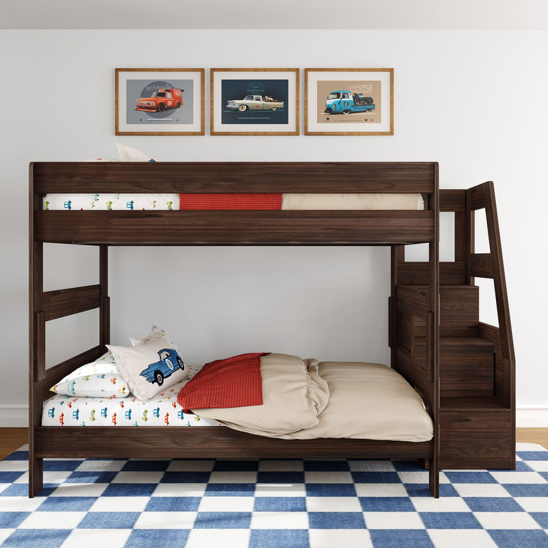 Dark wood kids bunk bed with built-in staircase, car-themed bedding, three vintage car wall art prints and blue checkered rug in modern children's bedroom